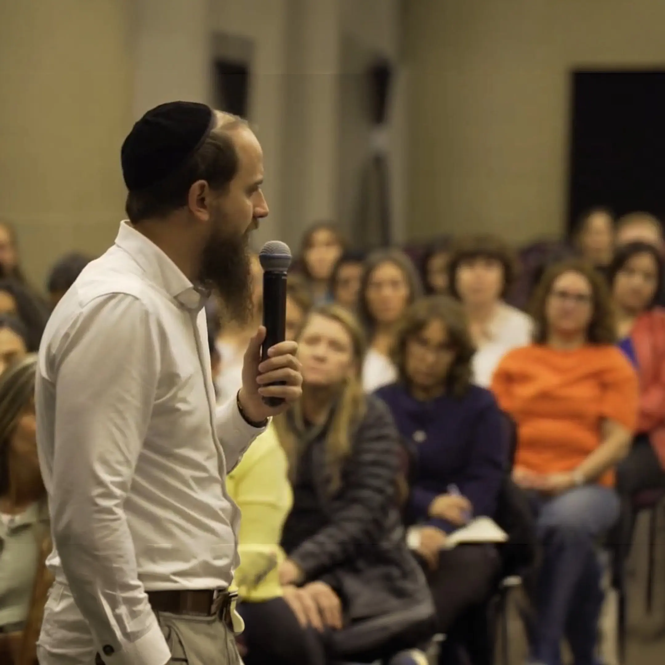 Daniel R. Chapán habla con un micrófono frente a un auditorio.